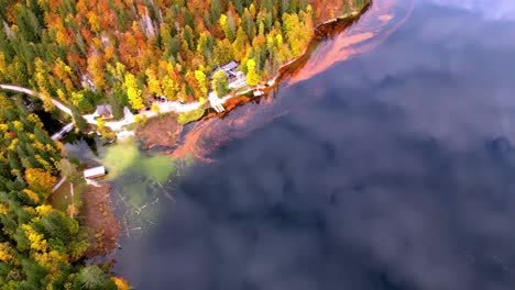 Una-Hermosa-Vista-De-Un-Lago-Dorado-Con-Un-Muelle-Y-árboles-Al-Fondo