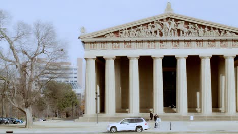 The-Partehnon-building-in-Nashville,-Tennessee-with-people-walking-close-up-video-panning-left-to-right