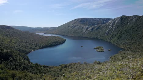 Toma-Aérea-De-Un-Lago-Rodeado-De-Colinas-En-Un-Día-Claro