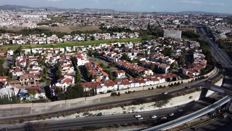 Traffic-on-highway-with-suburb-neighborhood-in-Mexican-City-of-Puebla-at-sunset