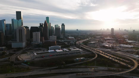 Tráfico-Frente-Al-Horizonte-De-Houston,-Atardecer-Nublado-En-Texas,-EE.UU.---Vista-Aérea