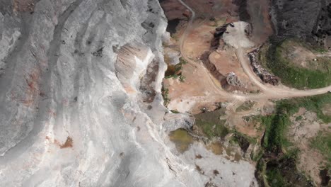 Aerial-top-down-view-Restoration-old-abandoned-quarry-steps-industry-trucks-unload-soil