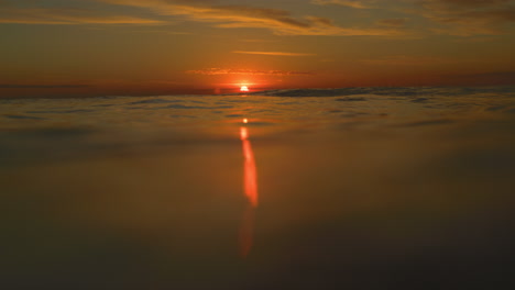 Meeresoberfläche-Mit-Roter-Abendsonne,-Die-In-Der-Abenddämmerung-Licht-In-Einem-Einzigen-Strahl-Wirft