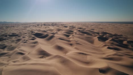 Un-Dron-Ascendiendo-Sobre-El-Desierto-De-Dunas-De-Arena-De-Glamis-Al-Amanecer.