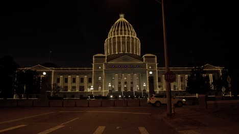 Arkansas-state-capitol-in-Little-Rock-Arkansas-at-night-with-holiday-lights-on-the-building-and-one-vehicle-driving-by-with-close-up-video-stable