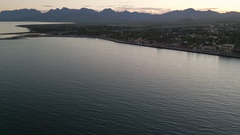 Drone-Vuela-Sobre-Loreto-Baja-California-Sur-México-Antigua-Ciudad-Colonial-Con-Mar-Golfo-Océano-Y-Montañas-Paisaje-Desértico-Al-Atardecer