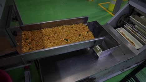 Cinematic-Shot-wide-angle-seen-Savory-food-is-going-inside-the-big-conveyor-line-from-the-machine