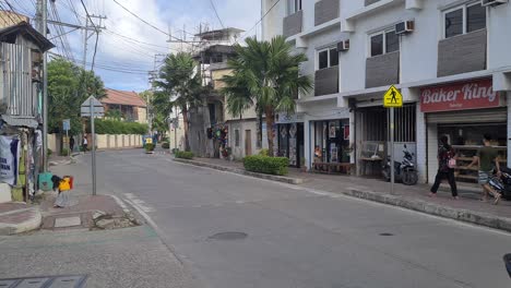 Street-Traffic-on-Boracay-Island,-Philippines,-Motorbikes,-Cars,-Shops-and-People-on-Sidewalks-60fps