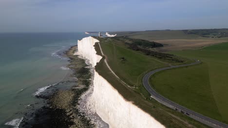 Aerial-view-of-chalk-cliffs-with-winding-road-by-the-sea-at-Beachy-Head