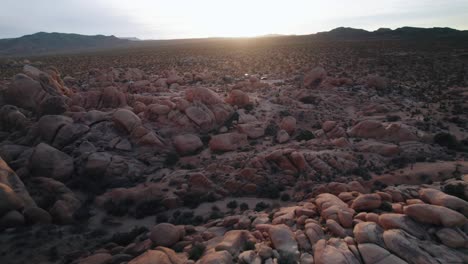 Drone-flying-between-rugged-steep-rock-formations-in-Joshua-Tree-National-Park-at-sunset