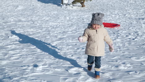 Happy-little-girl-throws-a-snowball-in-slow-motion-while-playing-at-snow-capped-park