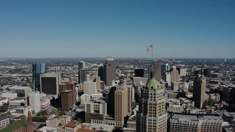 American-flag-flying-over-San-Antonio,-Texas-at-midday