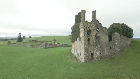 Aerial-View-Of-Carbury-Castle-And-Old-Graveyard-In-Daytime-In-Kildare,-Ireland