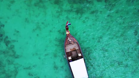Girl-lies-on-longtail-boat-in-bay-thailand