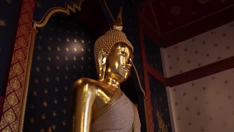 looking-at-a-golden-buddha-statue-in-a-temple-in-the-Rattanakosin-old-town-of-Bangkok,-Thailand
