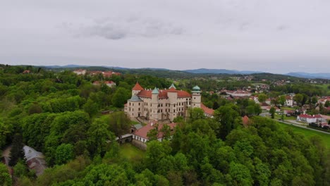 Castillo-De-Estilo-Barroco-Y-Renacentista-En-Una-Colina-Boscosa-Vista-Aérea-Romántica,-Polonia