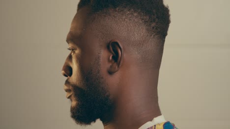 Close-Up-Portrait-Of-Bearded-Young-African-American-Man-Turning-His-Head-And-Looking-At-The-Camera