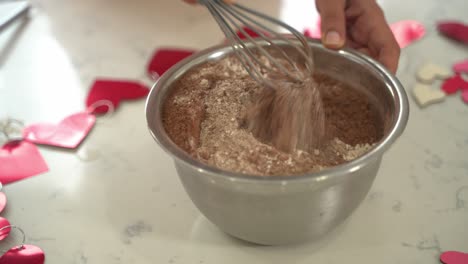 Hand-mixing-white-flour-into-a-dish-of-chocolate-flour-vegan-chocolate-cake-eggless-plant-based-dairy-free