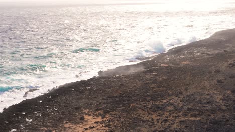 Rough-waves-crash-on-sharp-jagged-shore-of-northside-Curacao-with-sunlight-glistening-on-water