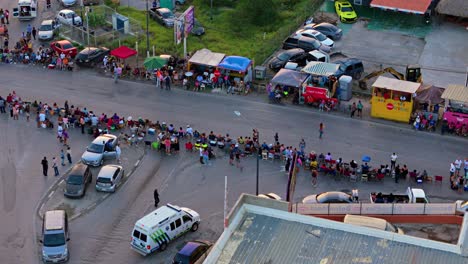 Emergency-ambulance-parks-behind-crowd-of-people-lining-up-at-parade
