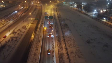 Antena-Siguiendo-Al-Equipo-De-Emergencia-De-Remoción-De-Nieve-Por-La-Noche-Mientras-Todos-Los-Carriles-Están-Despejados-Como-Equipo