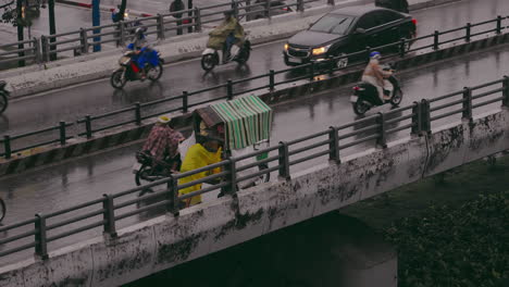 Man-Pushes-His-Cargo-Tricycle-Across-the-Bridge-Amidst-the-Rain