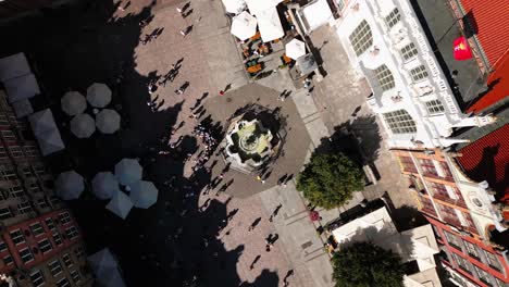 large-fountain-on-a-square-from-above,-old-town-city-centre,-danzig,-gdansk,-poland,-europe,-drone