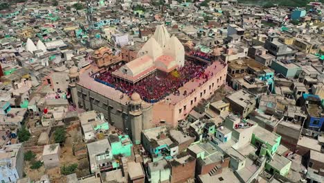 Aerial-drone-view-drone-camera-is-going-above-the-temple-where-many-people-are-playing-color