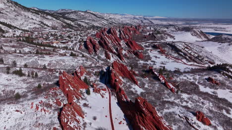 March-winter-morning-snow-stunning-Roxborough-State-Park-Littleton-Colorado-aerial-drone-over-sharp-jagged-dramatic-red-rock-formations-Denver-foothills-front-range-landscape-blue-sky-forward-reveal