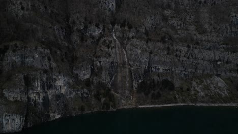 Vistas-of-rugged-mountain-scenery-and-cascading-waterfalls-from-a-bird's-eye-view,-all-set-against-the-picturesque-backdrop-of-Walensee-Unterterzen,-Switzerland