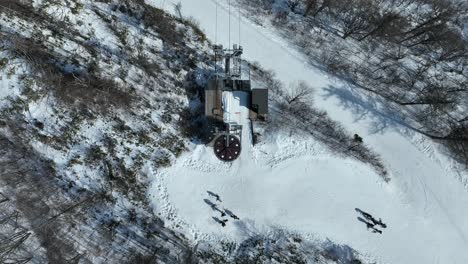 Top-down-shot-of-chair-lift-at-summit-of-mountain