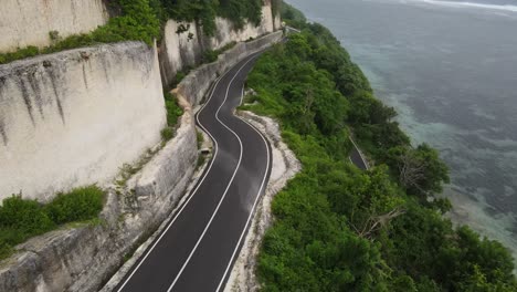 Luftaufnahme,-Asphaltierte-Klippenstraße-Und-Meer-Am-Strand-Von-Tanah-Barak,-Insel-Bali,-Indonesien