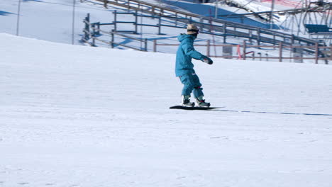 Ein-Snowboarder-Fährt-In-Zeitlupe-Den-Berghang-Oder-Die-Piste-Hinunter---Telefoto-Tracking