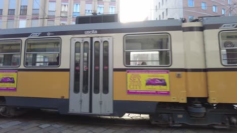 A-yellow-tram-streetcar-on-the-streets-of-Milan,-Italy