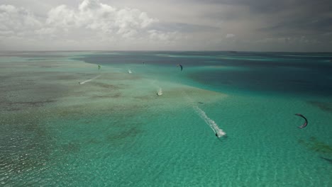 Un-Kitesurfista-Deslizándose-Sobre-Aguas-Turquesas,-Con-Una-Amplia-Vista-Al-Mar,-Una-Atmósfera-Serena-Y-Una-Vista-Aérea