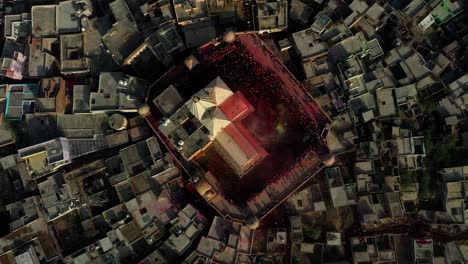 Aerial-drone-view-Drone-camera-shows-many-people-going-inside-the-temple-to-play-dhuleti-and-many-people-are-watching-the-people-playing-dhuleti-Residential-houses-are-visible