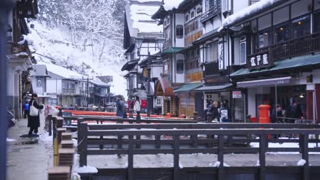 Focus-Rack-Reveal-of-Ginzan-on-Winter-Day-in-Northern-Japan,-Traditional-Hot-Springs-and-Hotels-Lining-River