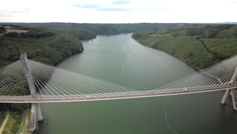 Arc-and-Zoom-In-Aerial-View-of-Suspension-Bridge-Over-River