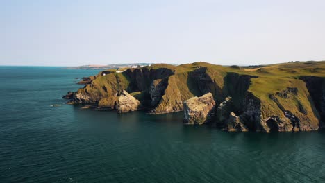 Exquisite-Aerial-View-of-St-Abbs-Head-Lighthouse-Perched-on-Dramatic-Cliffs,-Scottish-Borders,-Scotland