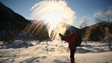 Woman-throw-hot-water-from-thermos-into-air,-turning-to-snow-in-freezing-temperatures,-Slow-motion-handheld