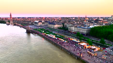Weinmesse-Versammelte-Menschenmengen-Am-Ufer-Des-Flusses-Garonne-Bei-Sonnenuntergang,-Luftaufnahme-Mit-Dolly-Rechts
