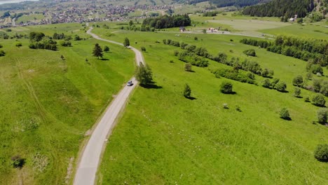 Auto-Fährt-Auf-Landstraße-Durch-Grüne-Sommerweide,-Polnische-Wiesenlandschaft