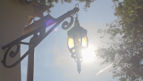 Slow-orbiting-shot-of-a-metal-lantern-hanging-on-the-side-of-a-villa