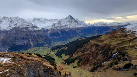 First-Cliff-metal-walk-way-Grindelwald-Switzerland-Swiss-Alps-snowy-Jungfrau-Junfrangu-glacier-Lauterbrunnen-mountain-peaks-October-cloudy-autumn-evening-landscape-sunset-valley-waterfalls-pan-left