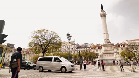 Plaza-Rossio-En-Cámara-Lenta,-La-Gente-Y-El-Tráfico-Viajan-En-El-Centro-De-Lisboa