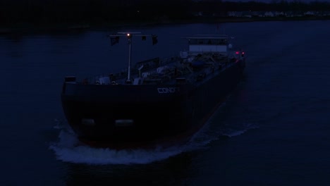 Cargo-Ship-Cruising-River-Of-Oude-Maas-At-Dusk-In-The-Netherlands---Drone-Shot