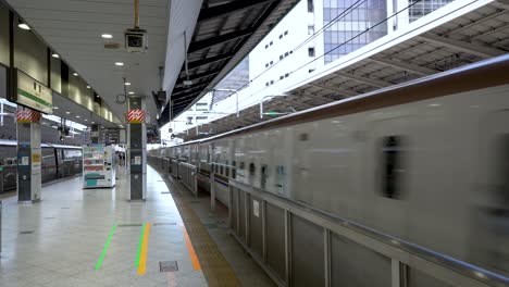 Una-Escena-Diurna-Captura-La-Salida-De-Un-Tren-Bala-Hokuriku-Shinkansen-Desde-El-Andén-De-La-Estación-De-Tokio,-Personificando-La-Modernidad-En-El-Transporte-Y-Los-Desplazamientos.