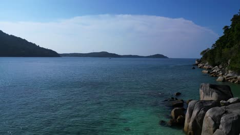 Tropical-paradise-secluded-serene,-sandy-beach-alongside-lush-forest-clear-blue-water