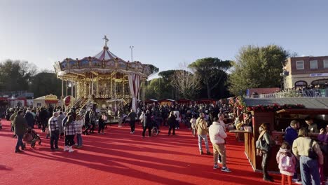 Old-fashioned-carousel-at-Christmas-market-with-people-walking-and-shopping-in-winter-season-in-Rome,-Italy