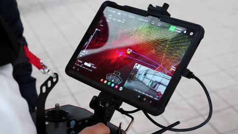 Drone-operator-with-remote-control-and-wide-tablet-screen-with-lidar-sensor-map